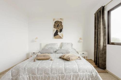 Dormitorio blanco con cama con almohadas en Serenity Haven, en Icod de los Vinos