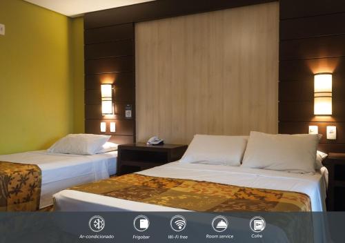 two beds in a hotel room with lights on the wall at Master Gramado Hotel - Espaço Kids Incrível in Gramado