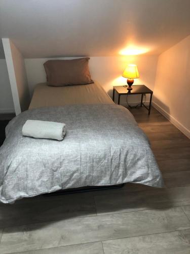 - une chambre avec un grand lit et une couverture blanche dans l'établissement Maison de ville vitry, à Vitry-sur-Seine