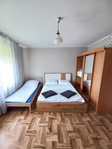 a bedroom with two beds and a wooden floor at Wiejski Relax pod "Żelaznym szlakiem" in Jastrzębie Zdrój