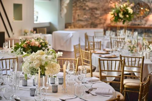 a table set up for a wedding with white flowers at Manor House Hotel in Bishop Auckland
