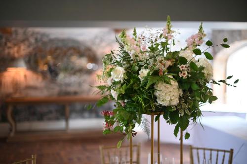 a vase filled with flowers on a table at Manor House Hotel in Bishop Auckland