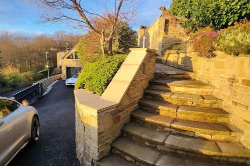 a set of stone stairs next to a brick wall at Luxury 1 Bed Coach House in Huddersfield
