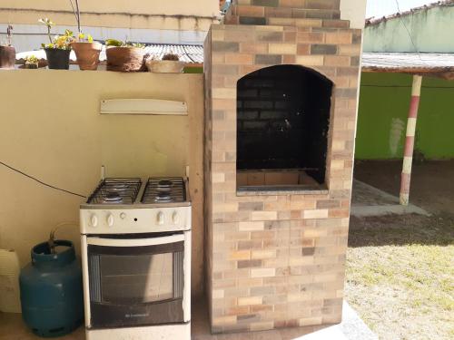 a outdoor kitchen with a stove and an oven at Pousada Village Piuma in Piúma