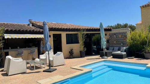 - une piscine avec des chaises et des parasols à côté d'une maison dans l'établissement Studio Le Pitchoun, à Pernes-les-Fontaines