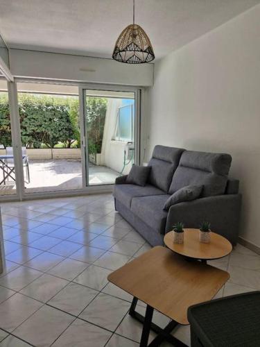 un salon avec un canapé et une table dans l'établissement Porte Océane studio spacieux avec parking, à La Rochelle