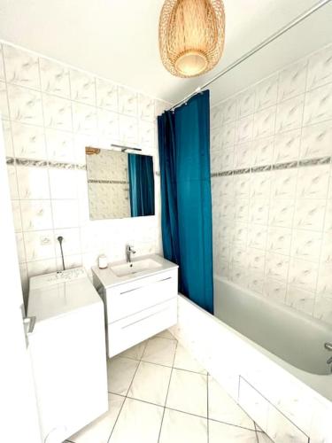 une salle de bain avec une baignoire et un lavabo et une baignoire dans l'établissement Porte Océane studio spacieux avec parking, à La Rochelle