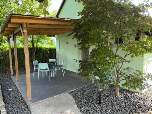 a patio with a table and chairs under a pergola at Green Oasis Garden in Šenčur