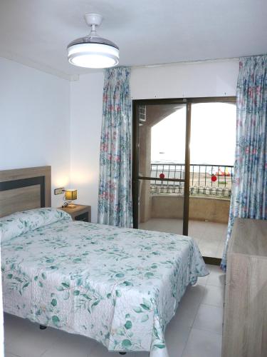 a bedroom with a bed and a large window at Playamar in Alcossebre