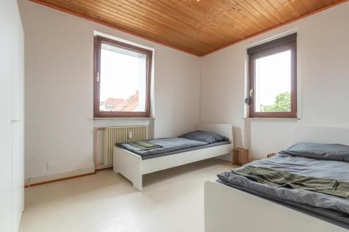 una camera da letto con due letti e due finestre di Monteurapartment I 12 Betten I Küche I Waschmaschine I Balkon I Nieder-Klingen a Nieder-Klingen