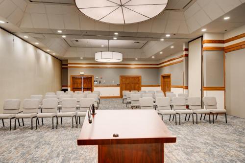 a conference room with white chairs and a podium at Holiday Inn West Yellowstone by IHG in West Yellowstone