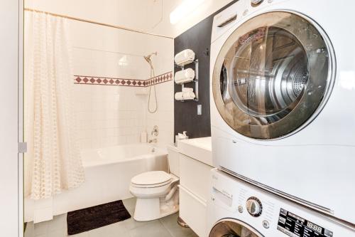 a white bathroom with a washing machine in it at Downtown Los Angeles Condo with Rooftop Pool Access in Los Angeles