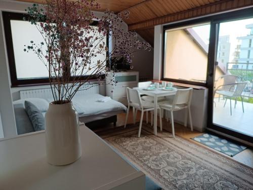 a room with a table and chairs and a vase with flowers at VillaMaria in Gdańsk