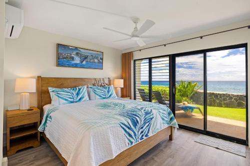 ein Schlafzimmer mit Bett und Blick auf das Meer in der Unterkunft Poipu Shores 107A in Koloa