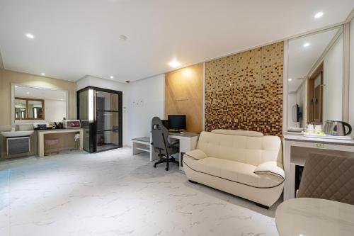 a living room with a couch and a desk at Time Hotel in Yangsan