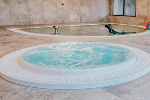 a large bath tub with blue water in the middle at STAR Apartament & Spa Dziwnów in Dziwnów
