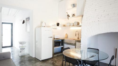 a kitchen with a table and a white refrigerator at Casas da Amieira - Casa Terracota in Amieira