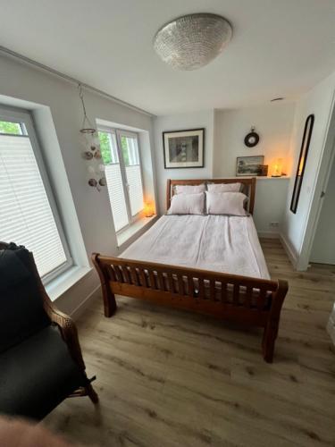 a bedroom with a large bed and two windows at Appartement Plein 1944 in Nijmegen