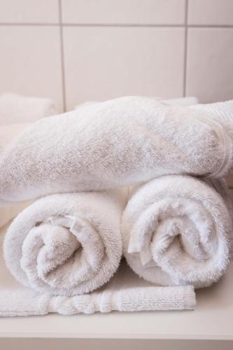 a pile of towels on a counter in a bathroom at Sander's Apartments Landstuhl in Landstuhl