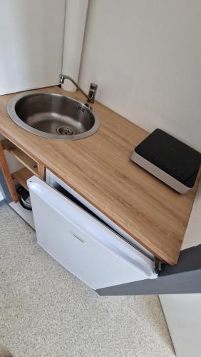 - un comptoir en bois avec lavabo dans la chambre dans l'établissement Domaine de Bernede, à Pomarez