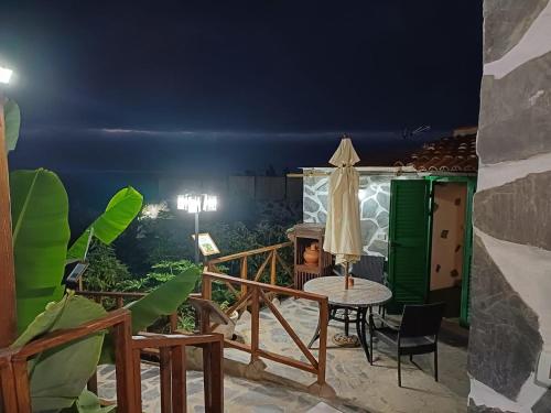 a patio at night with a table and umbrella at La Era de Catuja in Los Realejos