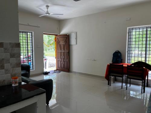 a living room with a table and a living room at Emerald Village in Kālapettai