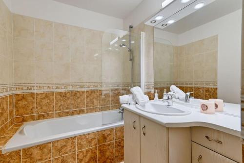une salle de bain avec un lavabo et une baignoire dans l'établissement duplex design, calme, au vallon des auffes, bord de mer, à Marseille