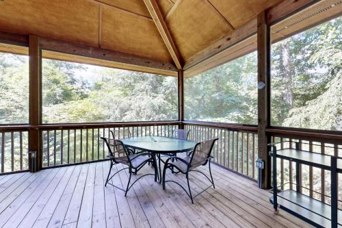 a screened in porch with a table and chairs on it at Rhymer Haven in Juno