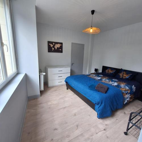 una camera da letto con un letto con una coperta blu di Appartement RDC centre ville - Local vélos disponible a Mayenne