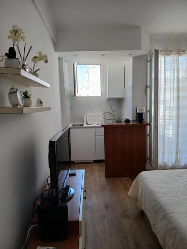 une chambre avec un lit et une cuisine avec une télévision dans l'établissement Maria, à Nice