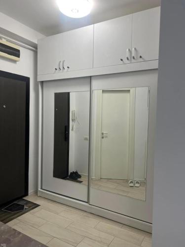 a bathroom with white cabinets and a walk in shower at AlyStar apartament in Mamaia Sat/Năvodari