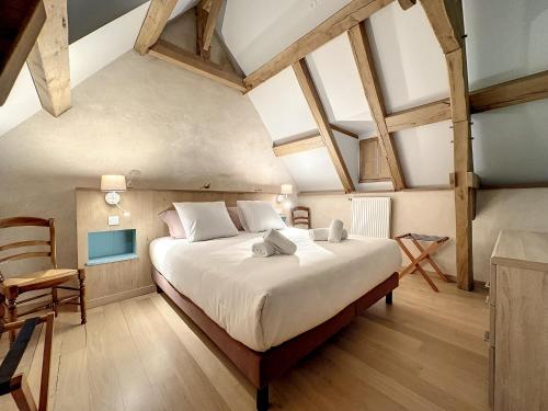 une chambre avec un grand lit et une chaise dans l'établissement Deux gites a la campagne 14 pers piscine jacuzzi, à Bourg-Blanc