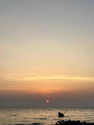 a boat in the ocean with the sunset in the background at Costa Azul, Necoclí in Necoclí