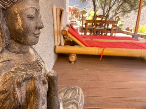 a statue of a woman sitting next to a bed at Casa Roja La Calera in Valle Gran Rey