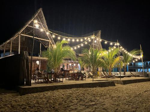 a restaurant on the beach at night with lights at Aluna Beach House Nungwi in Nungwi
