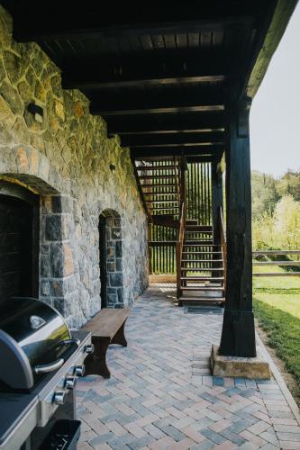 a stone building with a bench on a patio at Riverside House Krka in Zagradec