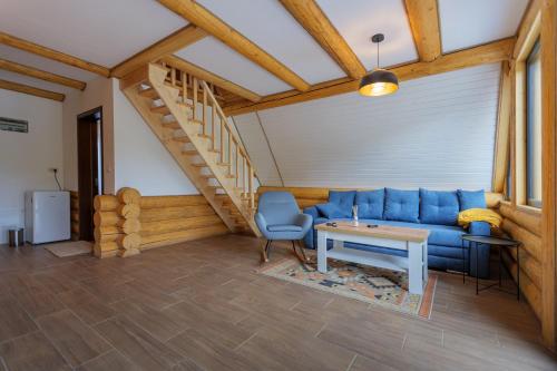 a living room with a blue couch and a table at Chilia Houses in Mănăstirea Humorului