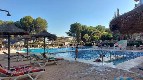 a person standing in a pool at a resort at Beautiful flat in Benalmádena