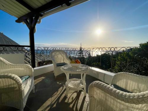 a balcony with chairs and a table with a view at Sunset View in Rivière Noire