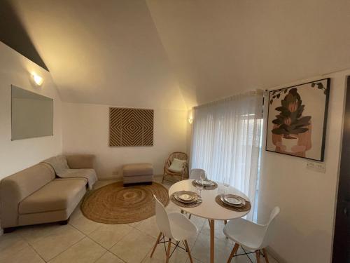 a living room with a couch and a table and chairs at Sunset View in Rivière Noire