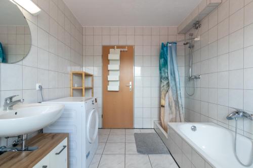 a bathroom with a sink and a washing machine at Monteurapartment I 8 Betten I Küche I Waschmaschine I Balkon in Münster