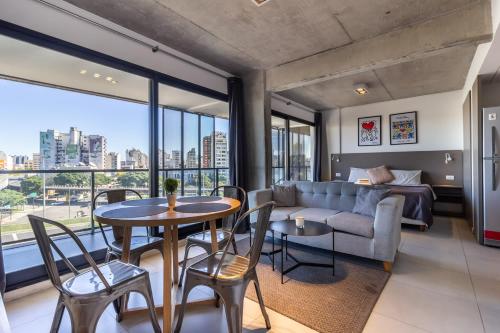 un salon avec un canapé, une table et des chaises dans l'établissement Loft Elegante a 5 Minutos de Puerto Madero 6B, à Buenos Aires