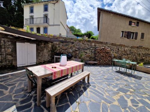 a wooden bench sitting on top of a stone patio at Appartement Llapasset in Formiguères