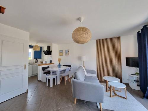 Cottage L'évasion des 2 caps-5 personnes- bord de mer في أودينجين: غرفة معيشة مع أريكة وطاولة