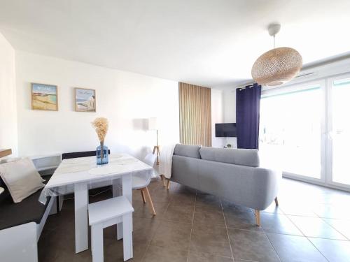 ein Wohnzimmer mit Sofa und Tisch in der Unterkunft Cottage L'évasion des 2 caps-5 personnes- bord de mer in Audinghen