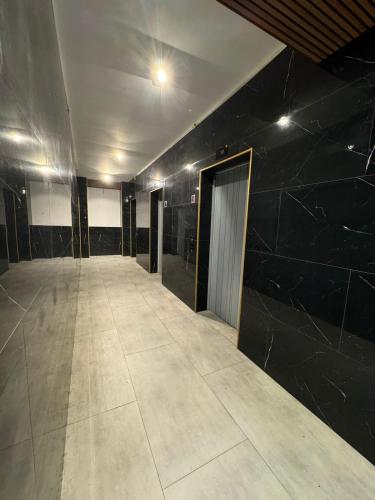 an empty hallway with black walls and a door at Moonlight Apart-Hotel Batumi in Batumi