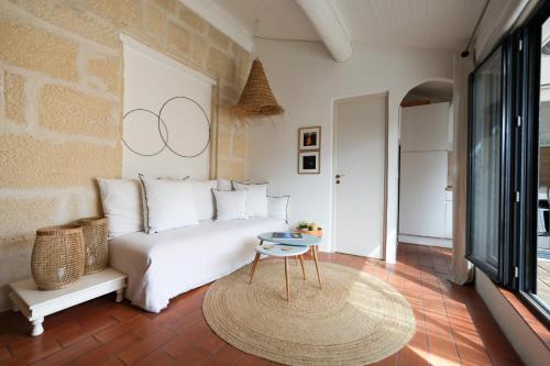 une chambre avec un lit blanc et une table dans l'établissement Arles sous les toits - Terrasse proche des arènes, à Arles