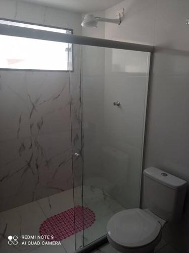 a bathroom with a glass shower with a toilet at Cobertura em Aperibé in Aperibé