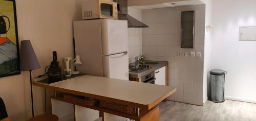 La cuisine est équipée d'un réfrigérateur blanc et d'un four micro-ondes. dans l'établissement La Fayette, à Cannes