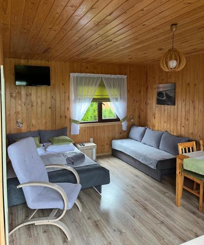 a living room with a blue couch at Domki letniskowe "Kwatery u Skrzacika" in Sianozety